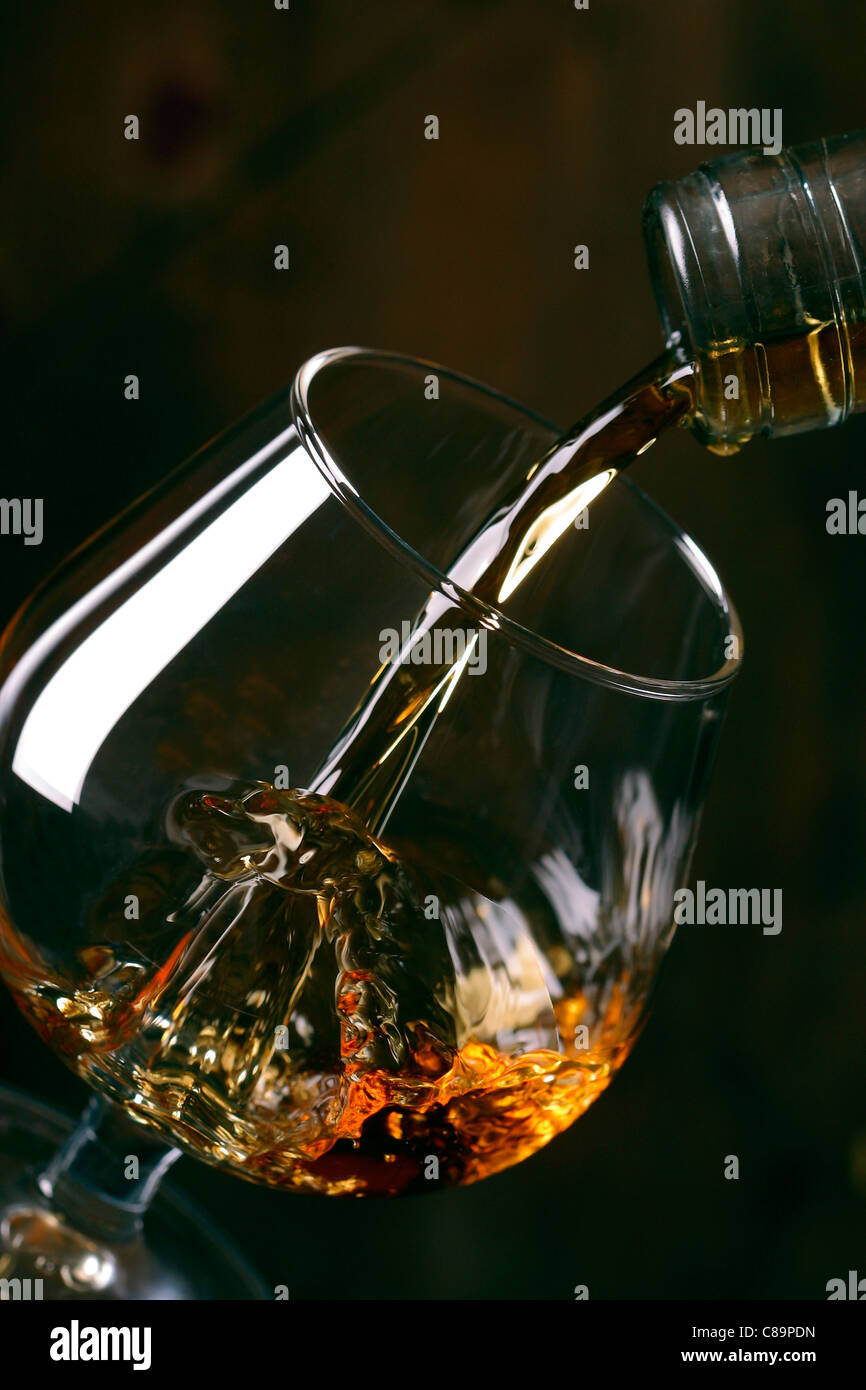 Schnaps in Glas gießen Stockfoto