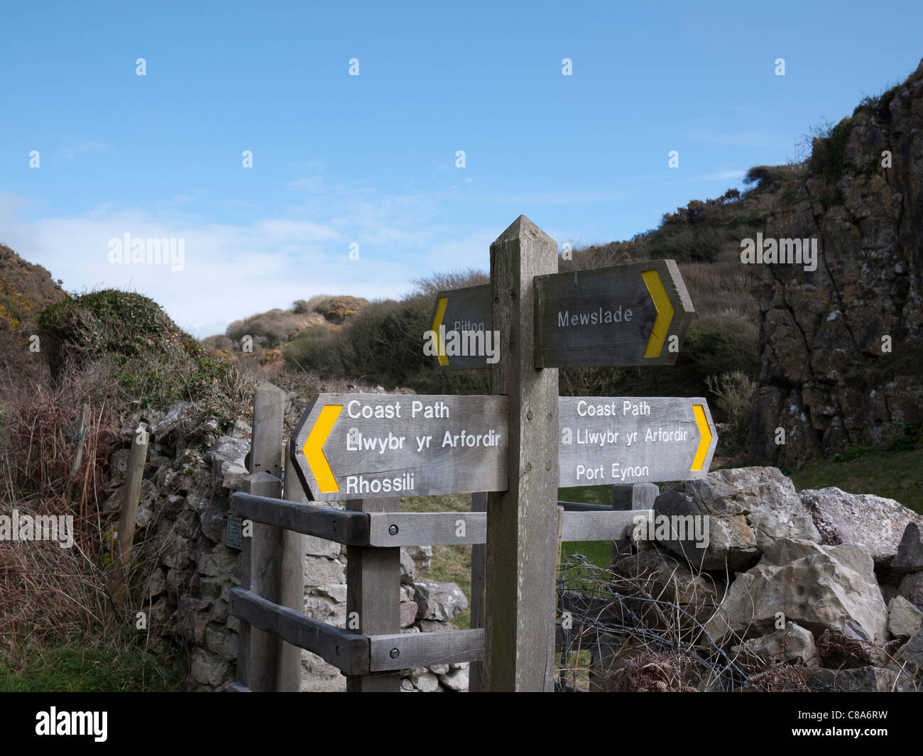 Eine hölzerne Wegweiser Richtung Rhossili und Port Eynon auf dem Küstenpfad zu geben, in der Nähe von Mewslade Bay in Süd-Wales. Stockfoto