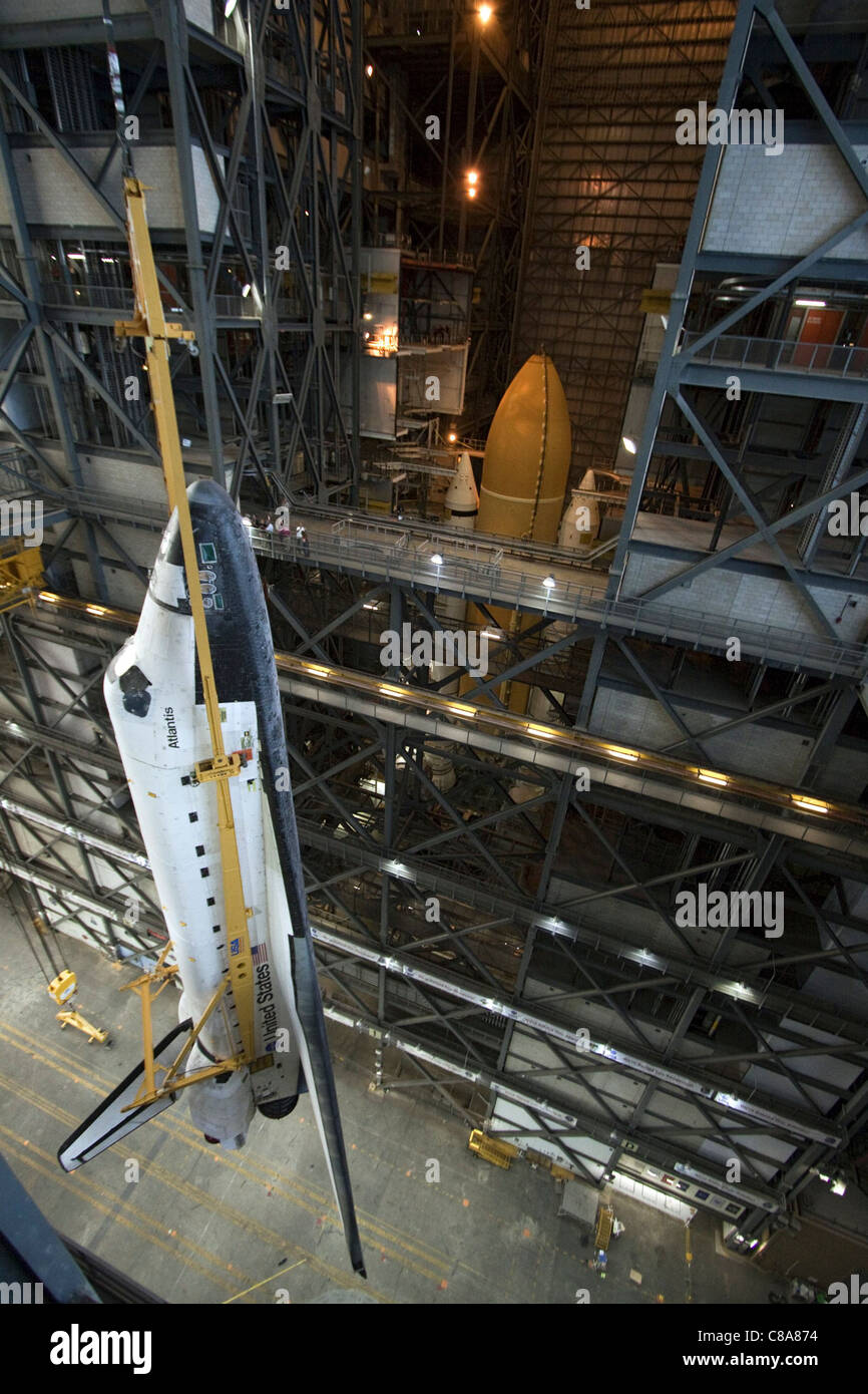 Shuttle Atlantis wird in die hohe Bucht des Fahrzeugmontagegebäudes des Kennedy Space Centers gebracht, wobei ein Überdachungskran für die Vorbereitung des Starts verwendet wird. Dies ist ein weiterer wichtiger Schritt in seiner Mission. Stockfoto Shuttle Atlantis wird in die hohe Bucht des Fahrzeugmontagegebäudes des Kennedy Space Centers gebracht, wobei ein Überdachungskran für die Vorbereitung des Starts verwendet wird. Dies ist ein weiterer wichtiger Schritt in seiner Mission. Stockfoto