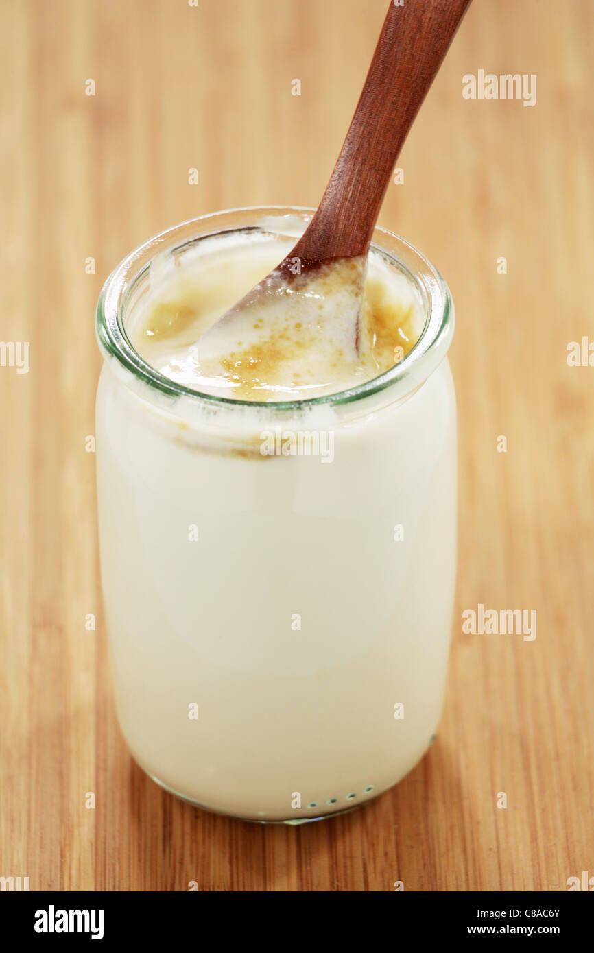 Naturjoghurt im Glas mit braunem Zucker Stockfoto