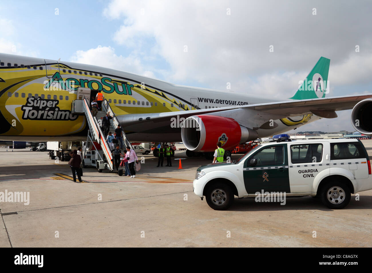 Fahrzeuge der Zivilwache, die neben dem Flugzeug Boeing 747 geparkt werden, während Passagiere von einem Aerosur-Flug von Bolivien aus am Flughafen Madrid Barajas, Spanien, aussteigen Stockfoto