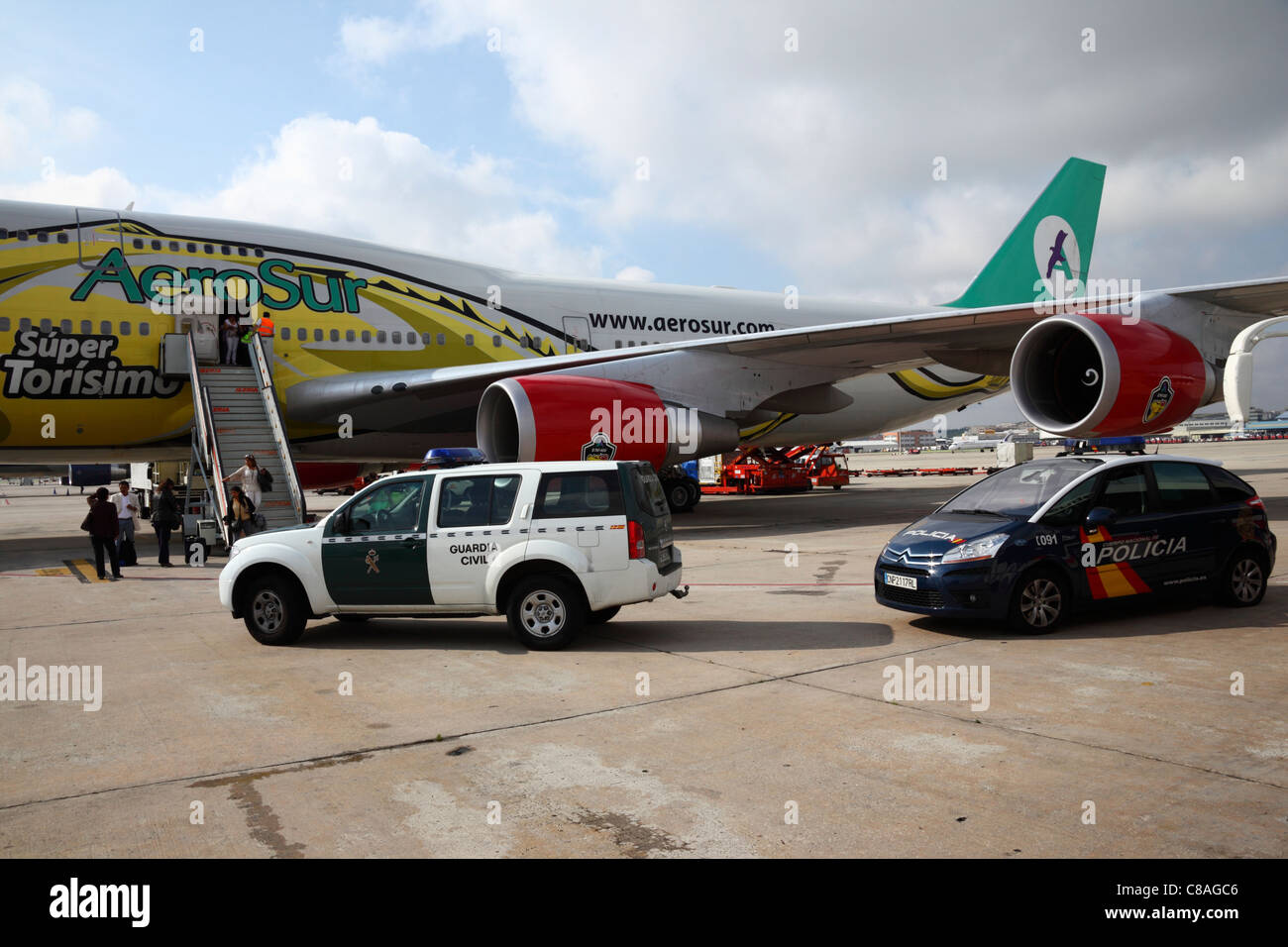 Zivilschutz- und Polizeifahrzeuge, die neben der Boeing 747 geparkt sind, während Passagiere aus dem Aerosur-Flug von Bolivien am Flughafen Madrid Barajas, Spanien, aussteigen Stockfoto