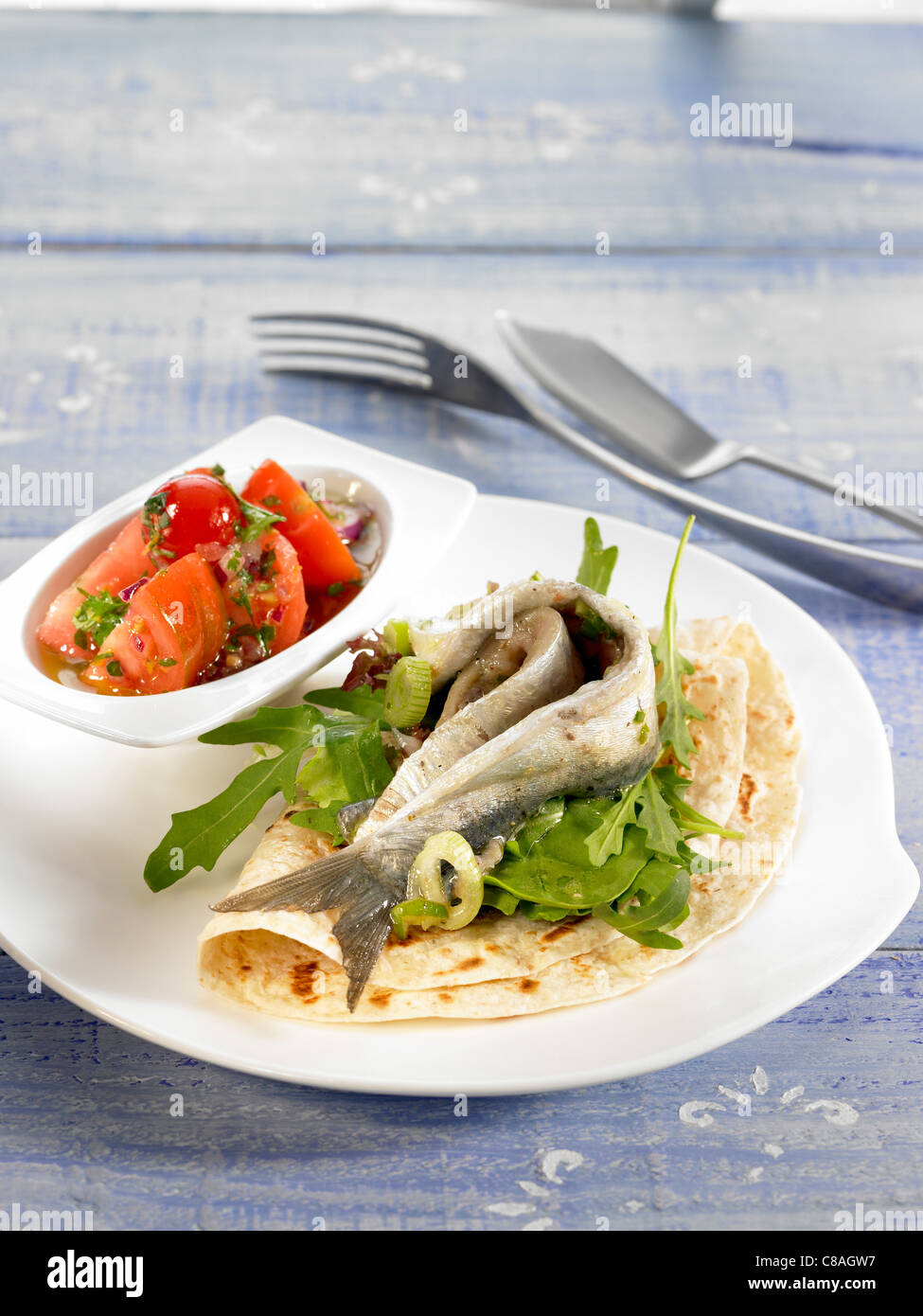Marinierte Sardinen-Tortilla mit Tomatensalat Stockfoto