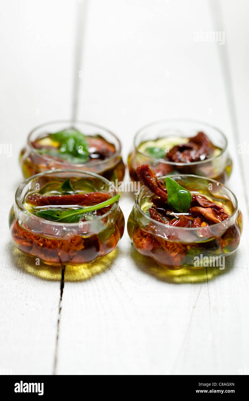 Olivenöl mit getrockneten Tomaten und Basilikum Stockfoto