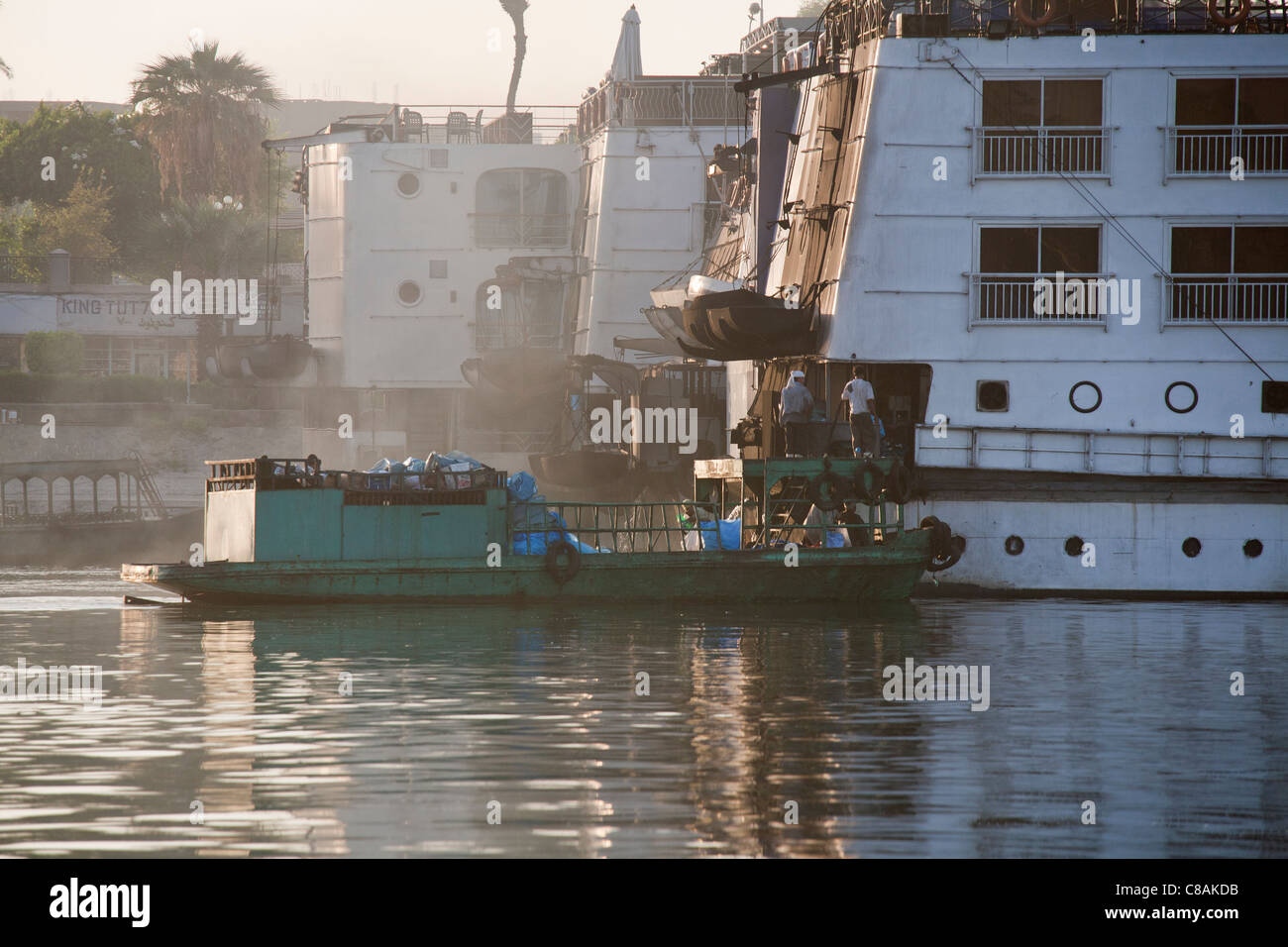 Ein Müll Sammlung Boot entfernen voll blaue Müllsäcke festgemacht an der Seite einer Nil-Kreuzfahrt-Schiff, Ägypten Afrika Stockfoto