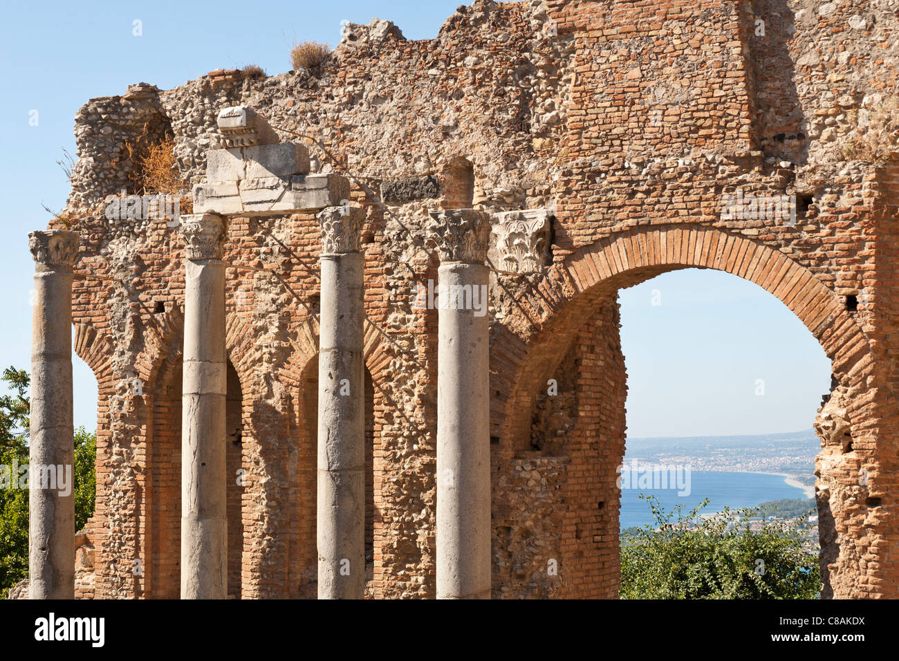 Spalten und Wand innerhalb des griechischen Theaters, und Blick auf den Golfo Di Naxos, Taormina, Sizilien, Italien Stockfoto