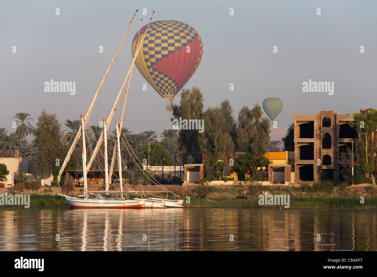 Abschnitt des Nil Flusses mit Ankern Fellucas und zwei niedrige fliegenden Heißluftballons in den Himmel zurück, Ägypten, Afrika Stockfoto