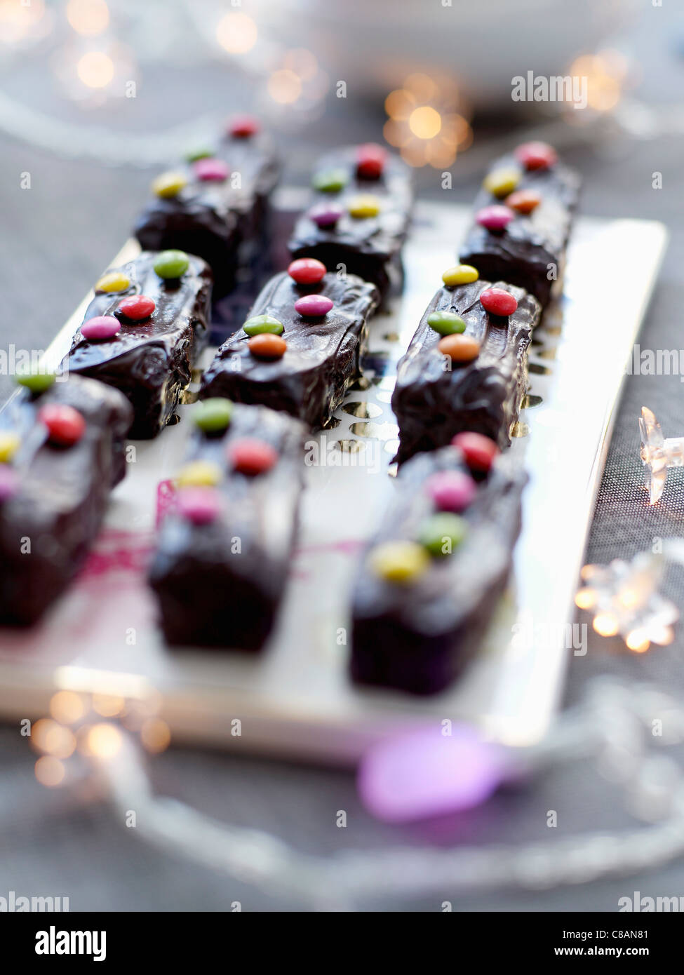 Kleine Schokolade Log Kuchen verziert mit Smarties Stockfoto