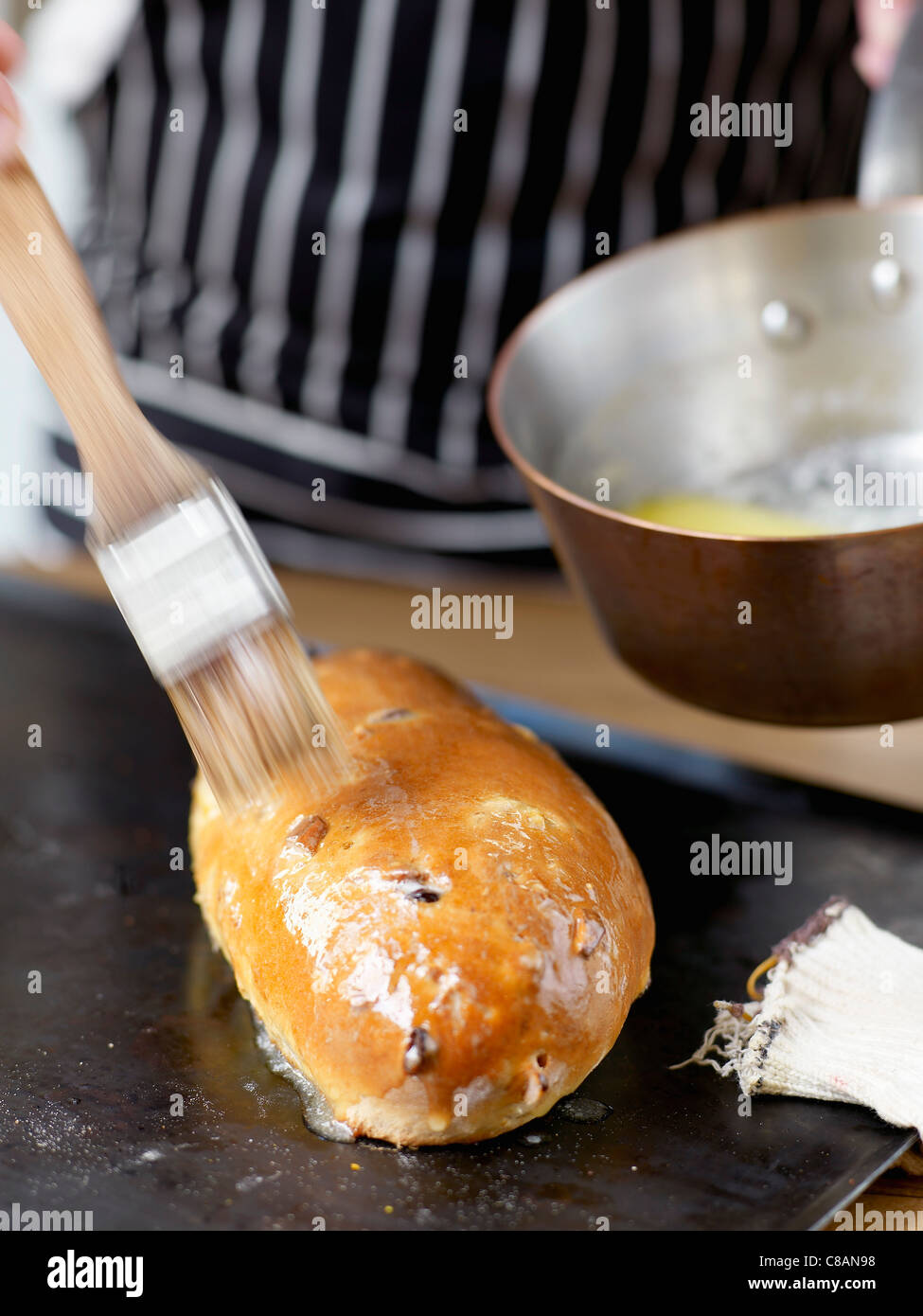 Geschmolzenen Butter auf die Stollen während unausgegoren Bürsten Stockfoto