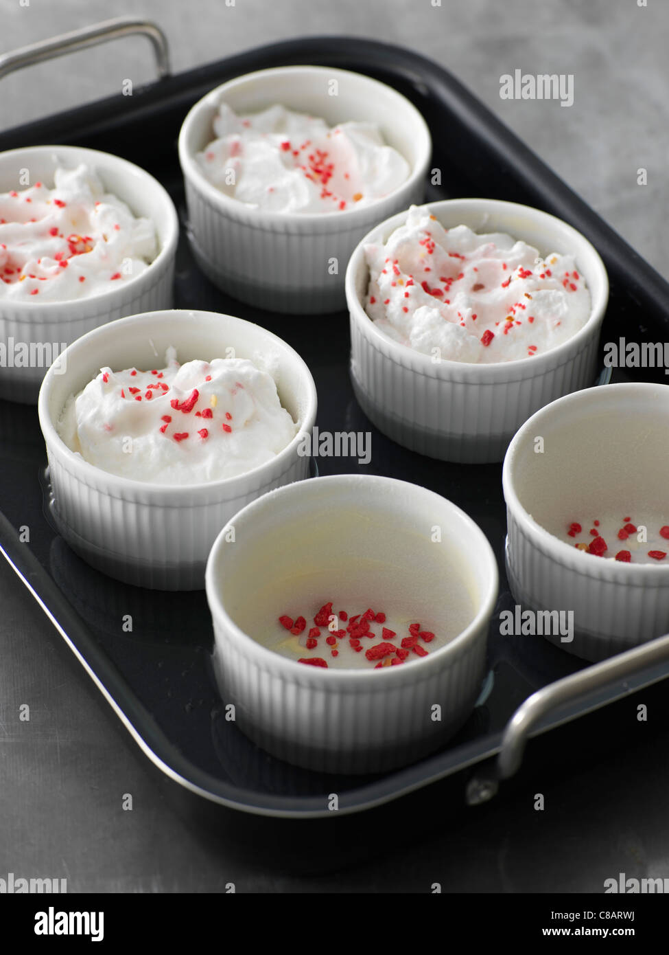 Das Eiweiß mit rosa Pralinen im Wasserbad kochen Stockfoto