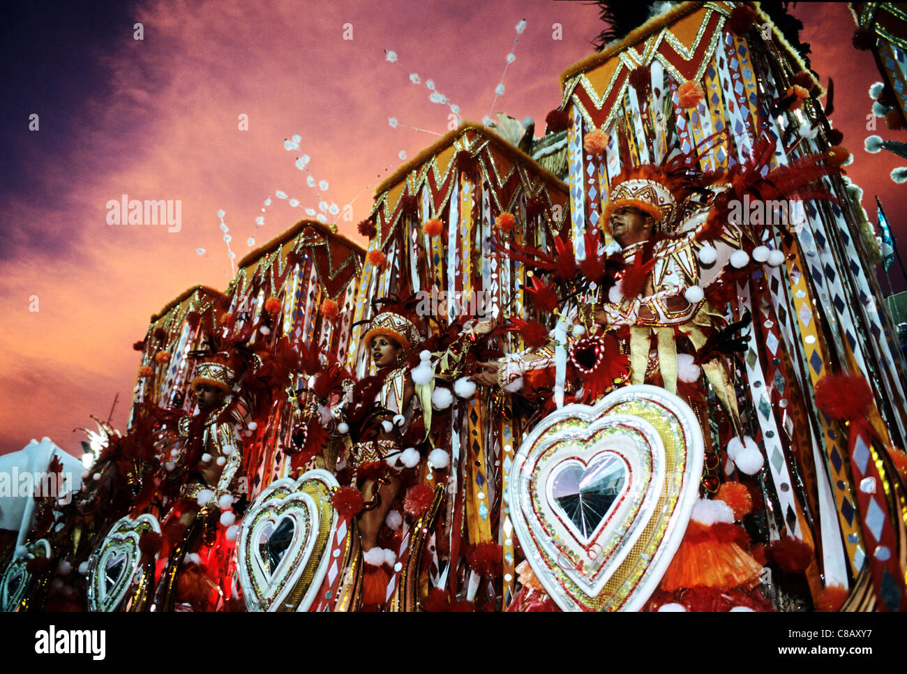 Rio De Janeiro, Brasilien. Karneval; Portela Samba Schule Schwimmer mit roten und weißen Kostümen. Sapucai Sambadrome im Morgengrauen. Stockfoto