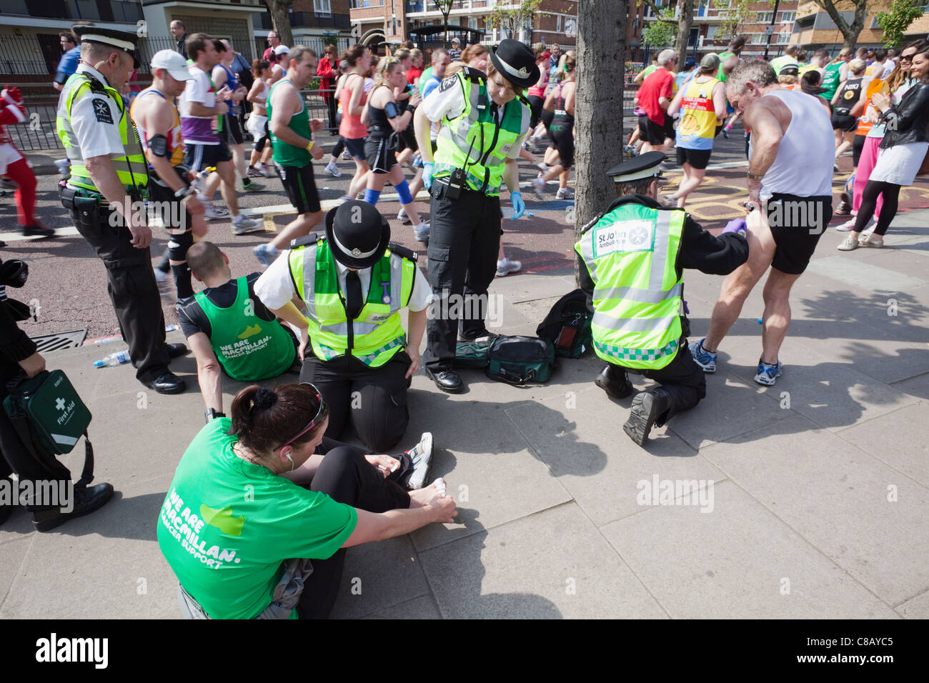 England, London, London-Marathon, St. John Ambulance Personal Behandlung von verletzten Läufer Stockfoto