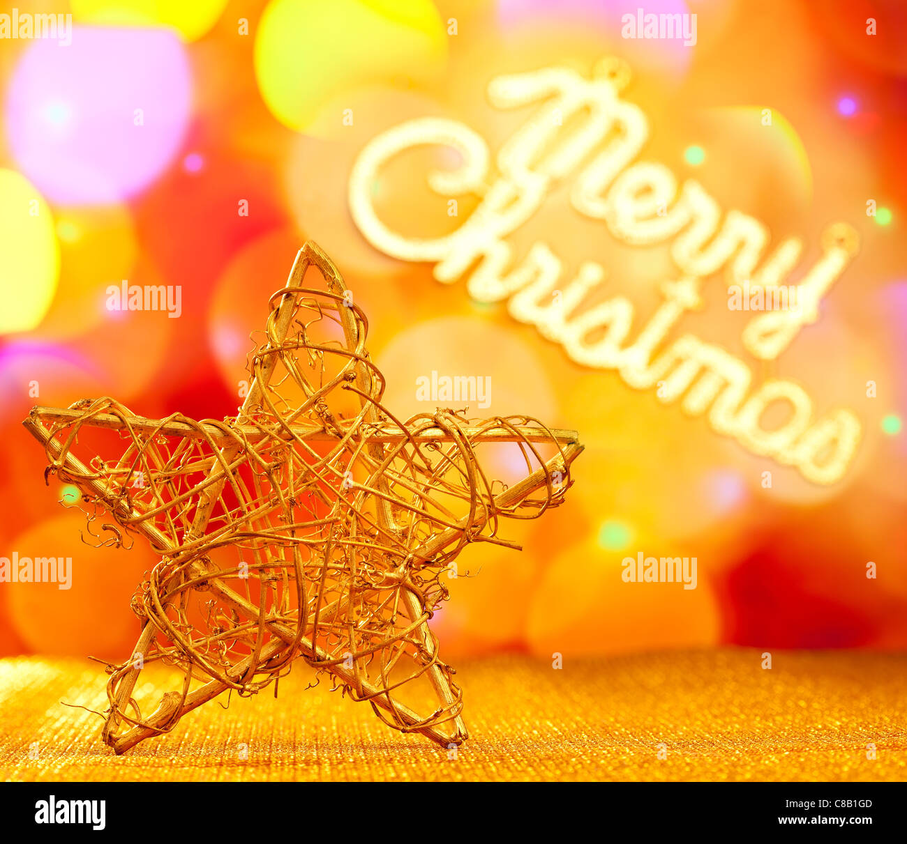 Goldener Stern mit Frohe Weihnachten in Lichter Hintergrund geschrieben Stockfoto