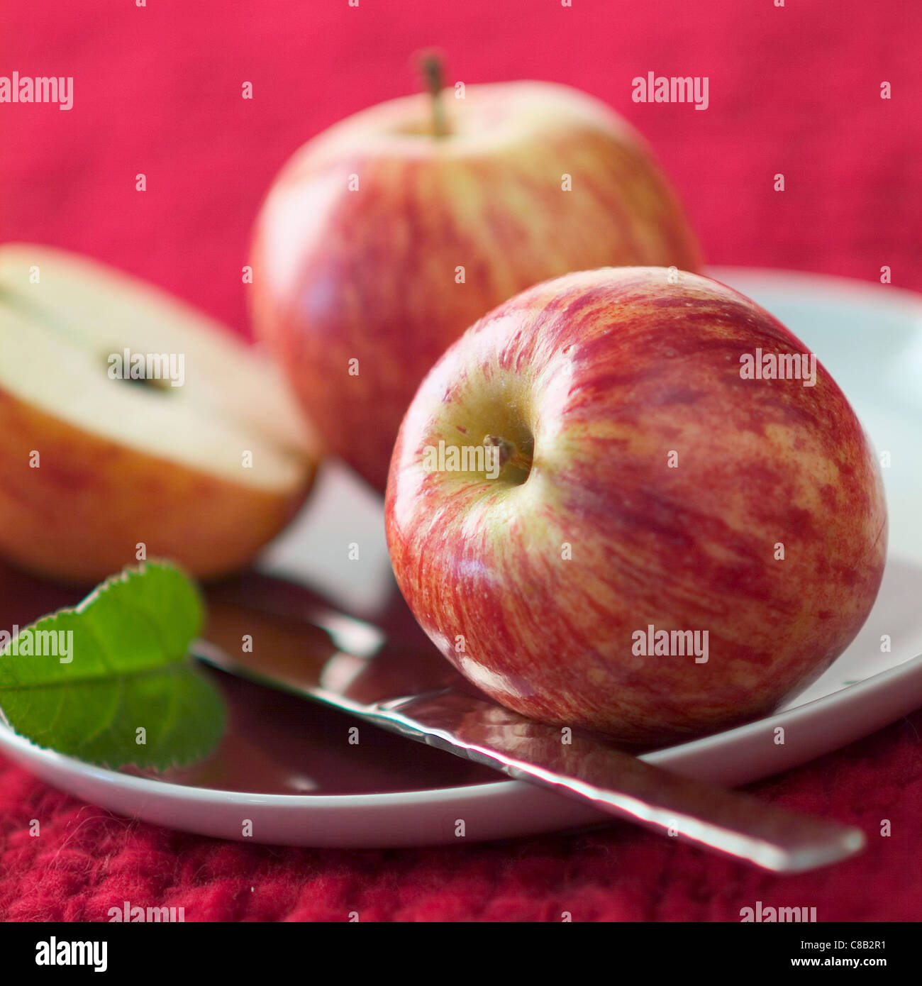 Ganze und geschnittene Äpfel mit Messer Stockfoto