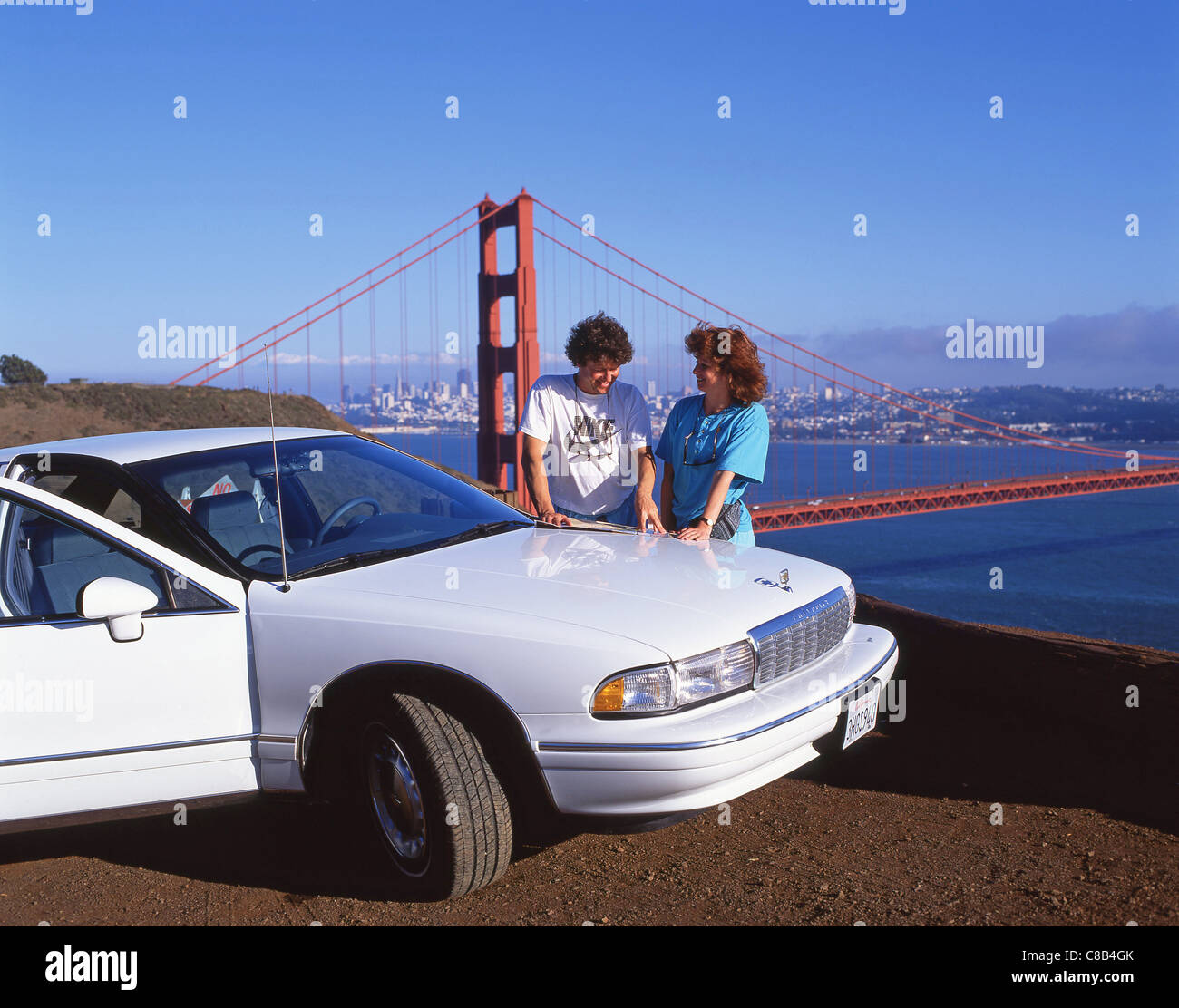 Paar mit Mietwagen und Golden Gate Bridge, Marin County, San Francisco, California, Vereinigte Staaten von Amerika Stockfoto