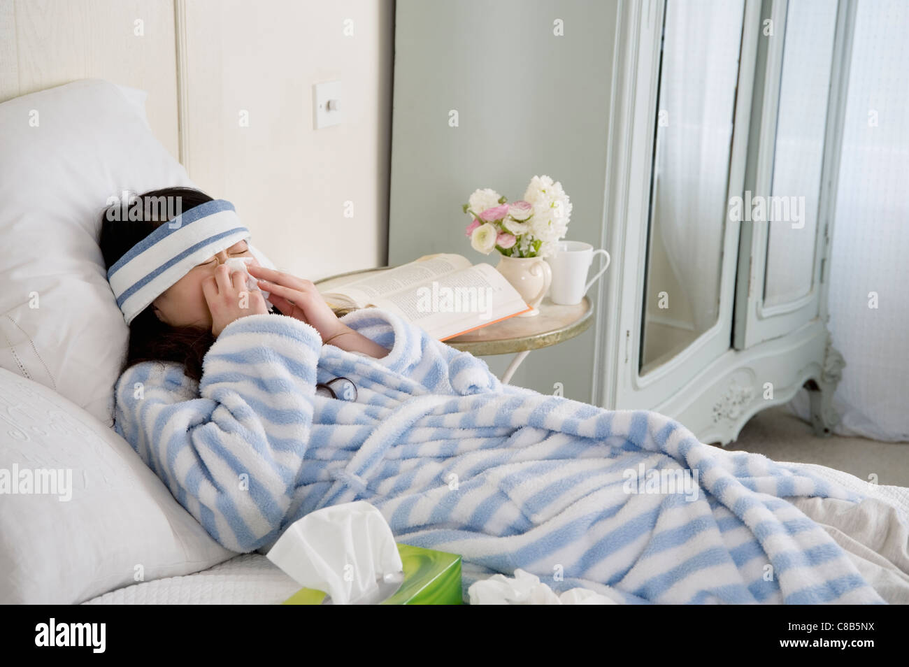 Junge Frau krank im Bett Stockfoto