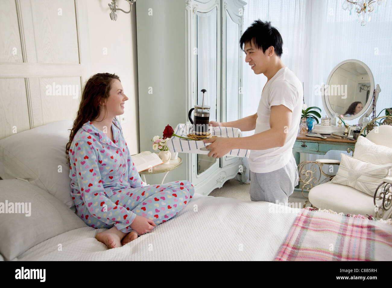 Mann Frau Frühstück im Bett zu bringen Stockfoto
