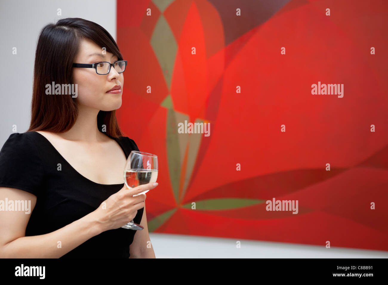 Junge Frau betrachten Wandmalereien in Kunstgalerie Stockfoto