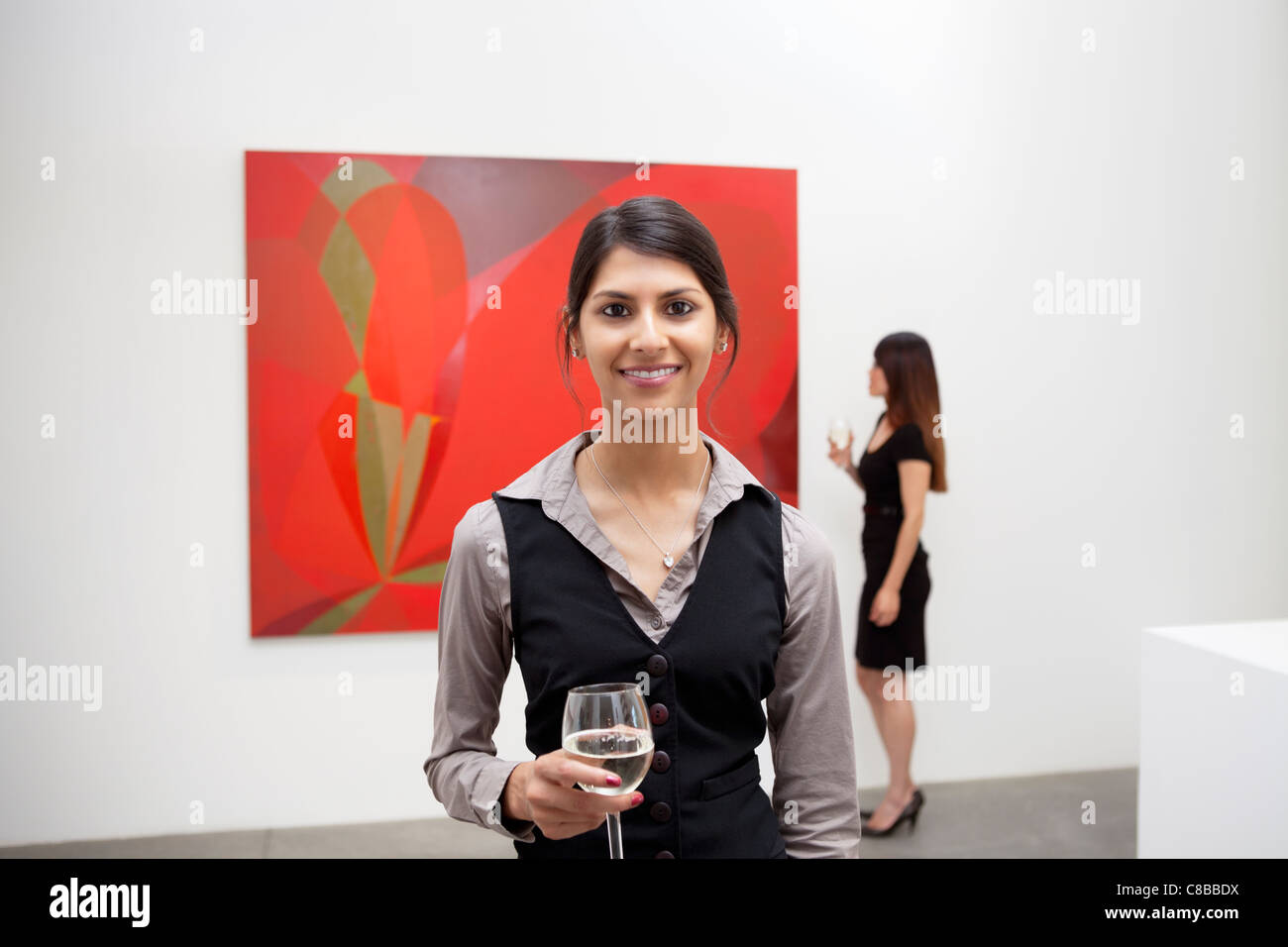 Porträt der jungen Frau vor Malerei in Kunstgalerie Stockfoto