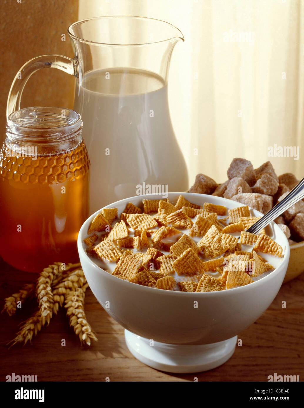 Frühstück mit Schüssel mit Müsli, Milch und Honig Stockfoto