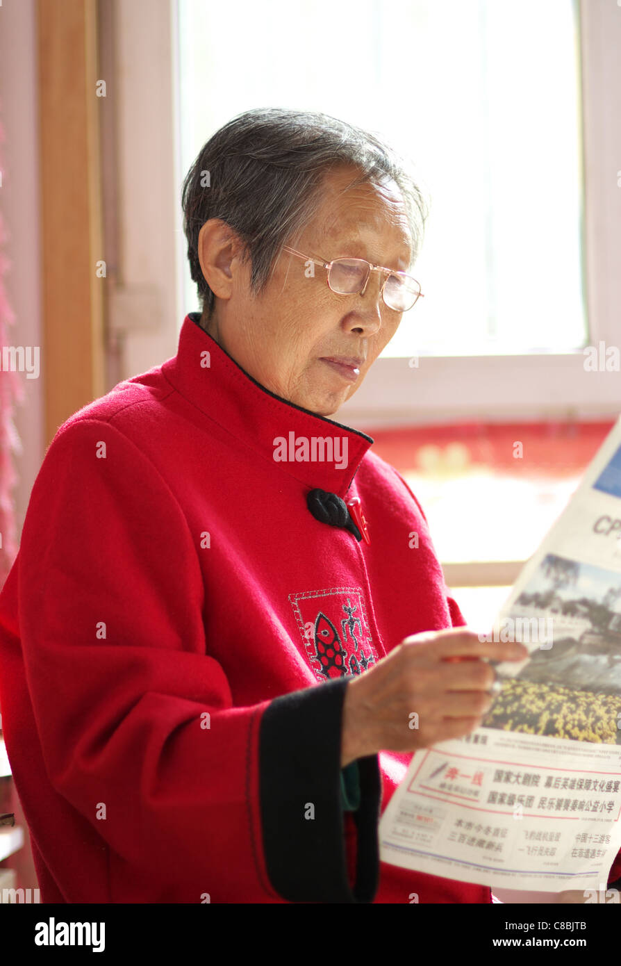 Asiatin senior lesen Zeitung Stockfoto