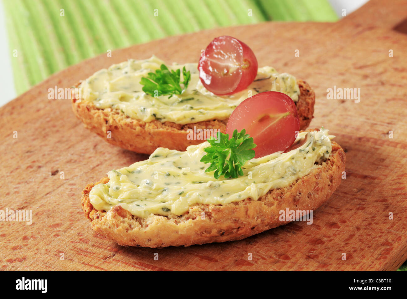 Knusprige Brötchen Vollkornbrot und Kräuterbutter Stockfoto