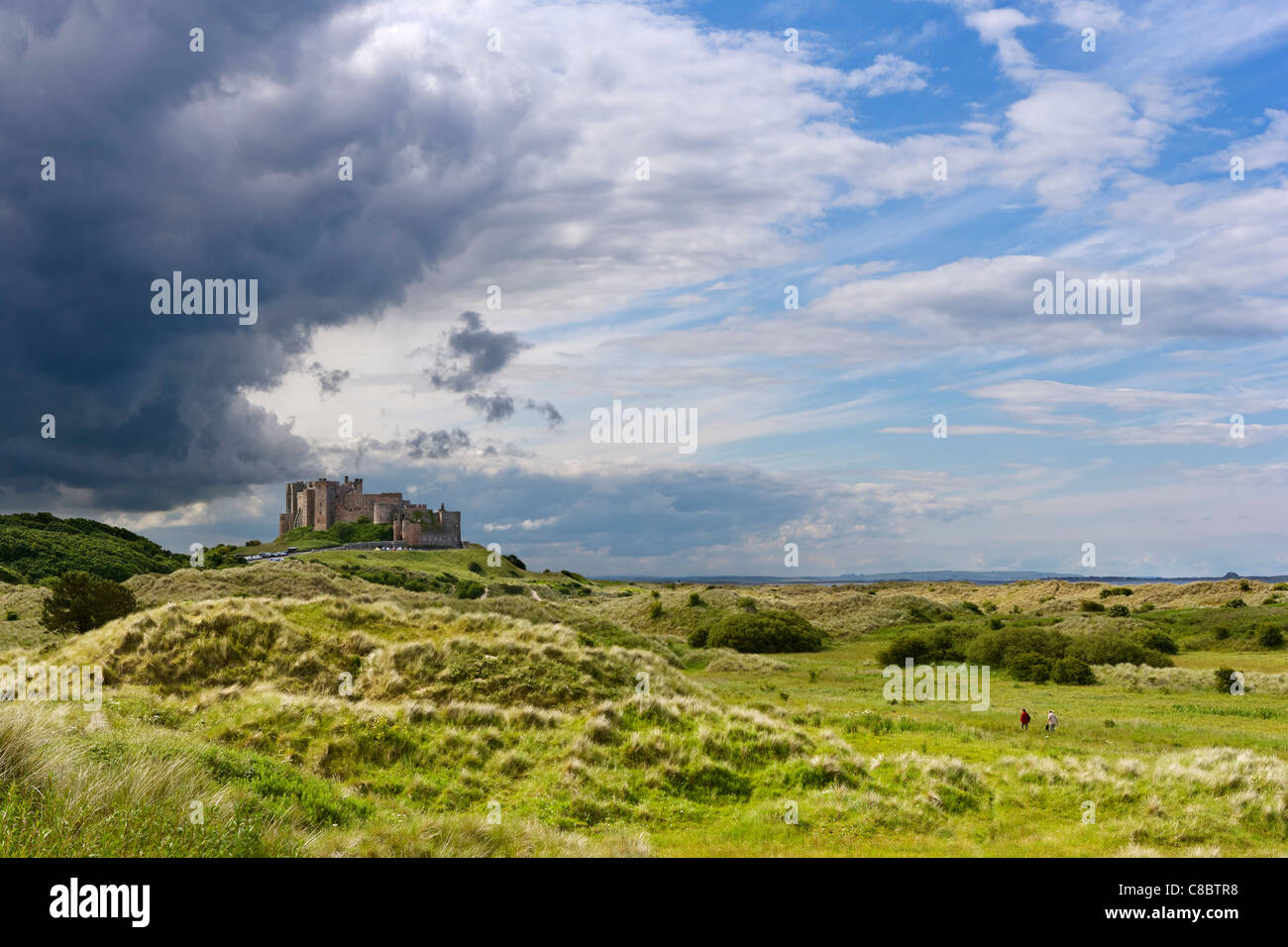 Blick über die Dünen zum Bamburgh Castle in Northumberland Küste, Nord-Ost-England, Großbritannien Stockfoto