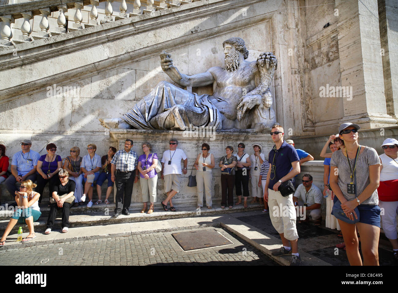 Touristen sind von einer riesigen Statue vertritt den Nil mit der Piazza del Campidoglio in Rom in den Schatten gestellt. Stockfoto