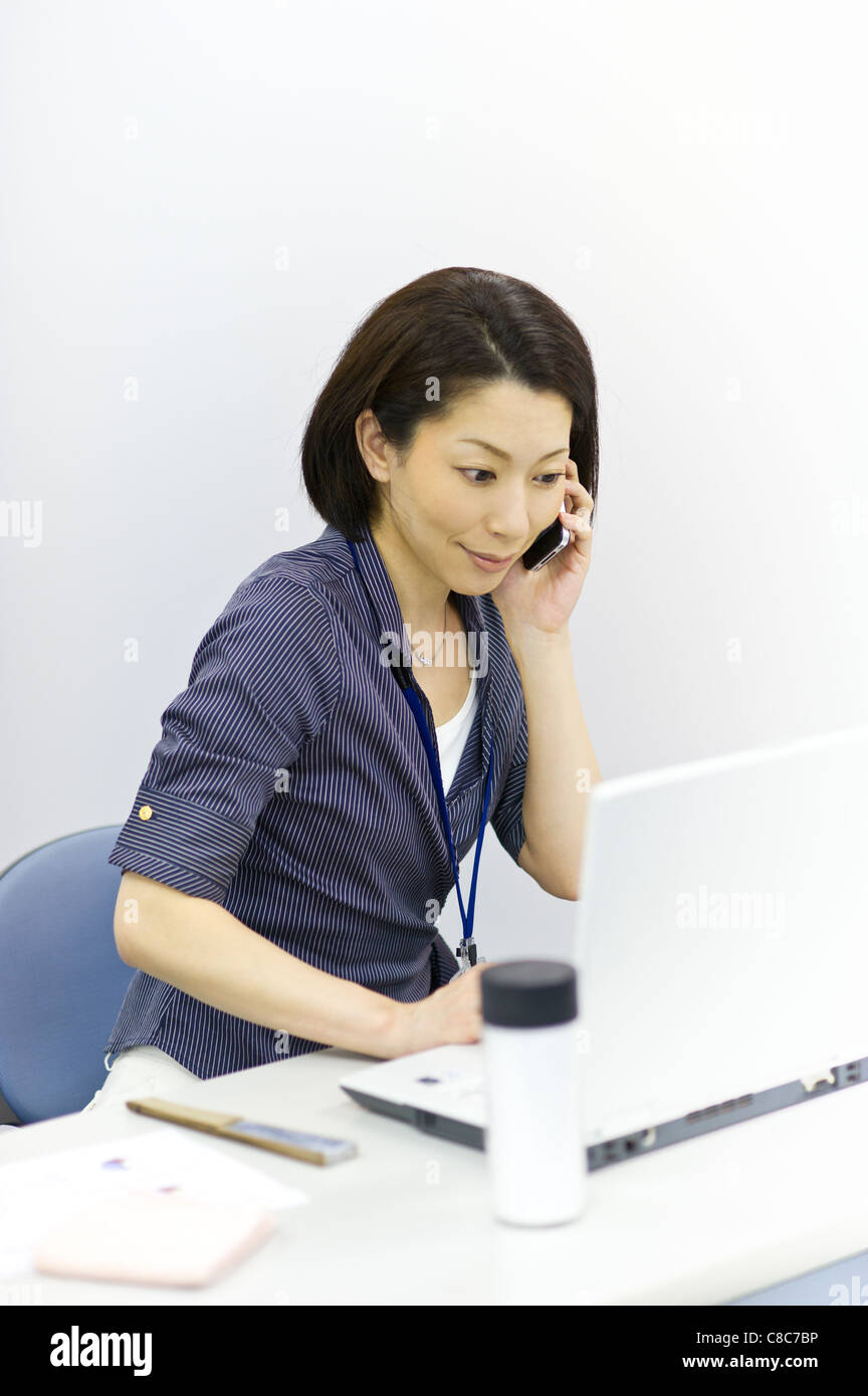 Mitte Erwachsene Frau hält Smartphone und Laptop suchen Stockfoto