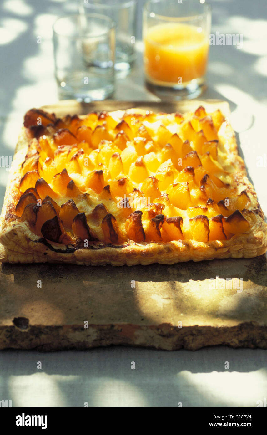 Aprikosen-Tarte mit Glas Orangensaft Stockfoto