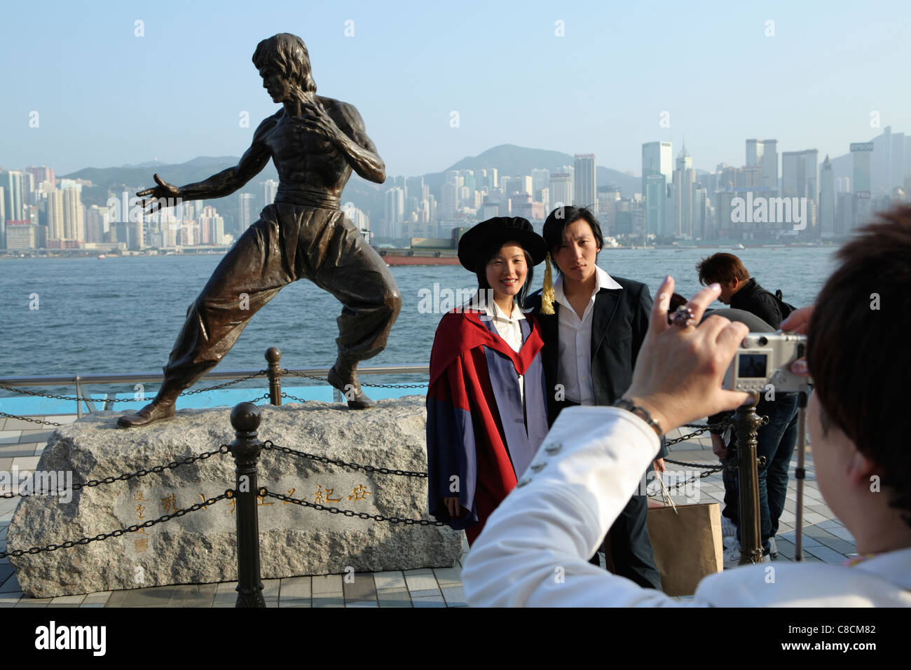 Absolventinnen Und Absolventen Posieren Fur Fotos Von Statue Der Hong Kong Martial Arts Und Filmstar Bruce Lee 1940 73 Auf Der Avenue Of The Stars Stockfotografie Alamy