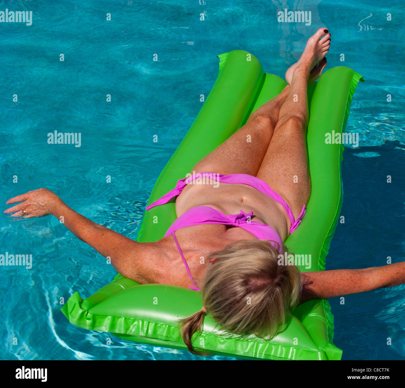 Frau auf eine Lilo in einem Swimmingpool Sonnenbaden. Stockfoto