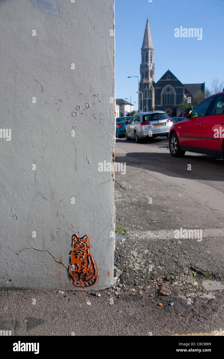 Graffiti-Malerei Katze auf der Ecke des Gebäudes mit Kirche im Hintergrund Roath Cardiff Wales UK Stockfoto