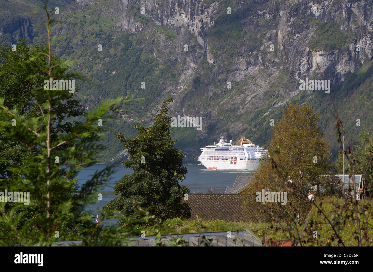 Blick auf Kreuzfahrtschiff durch Bäume. Norwegen, Geiranger fjord Stockfoto