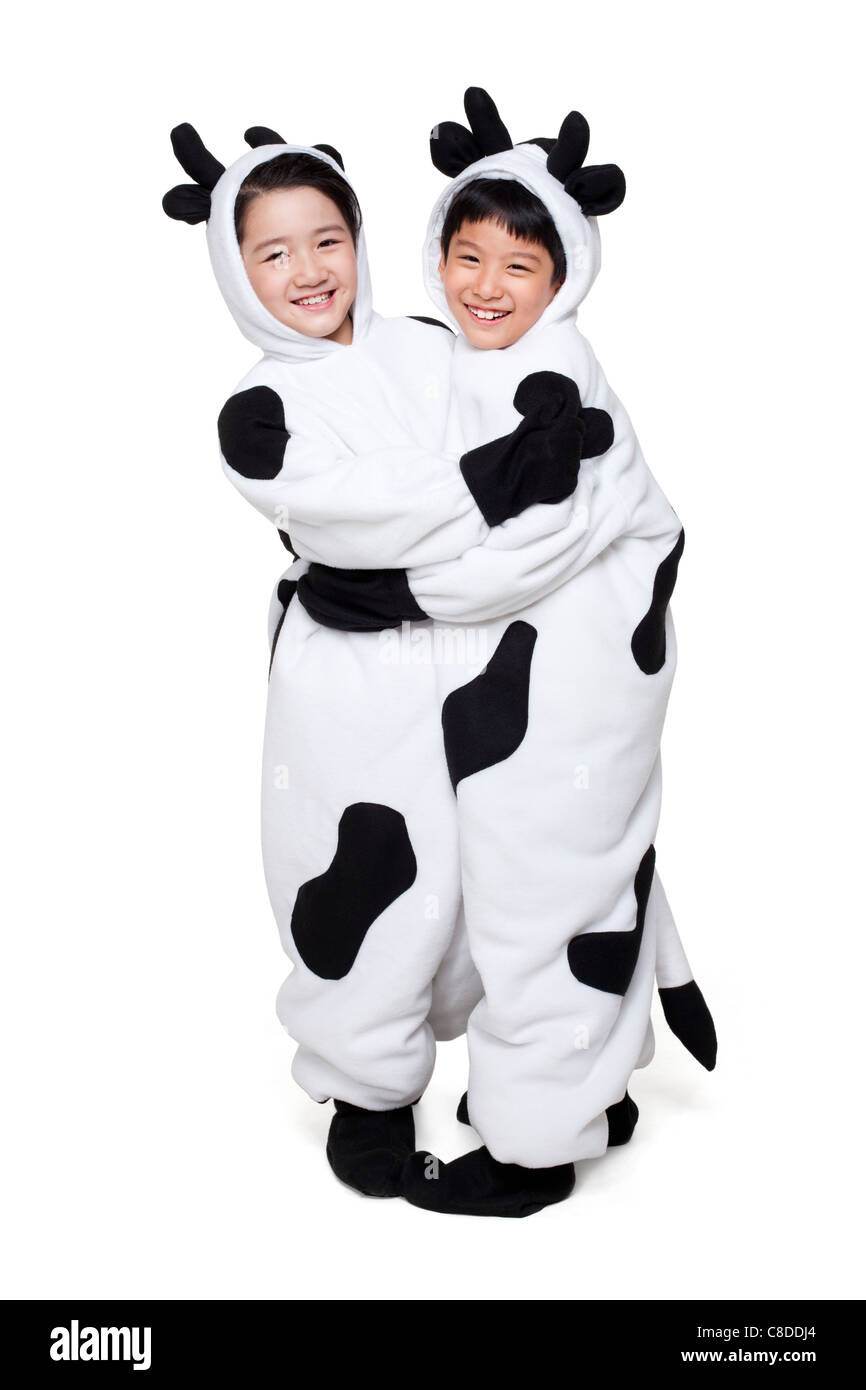 Jungen und Mädchen gekleidet in Kuh Kostüme Umarmung Stockfoto