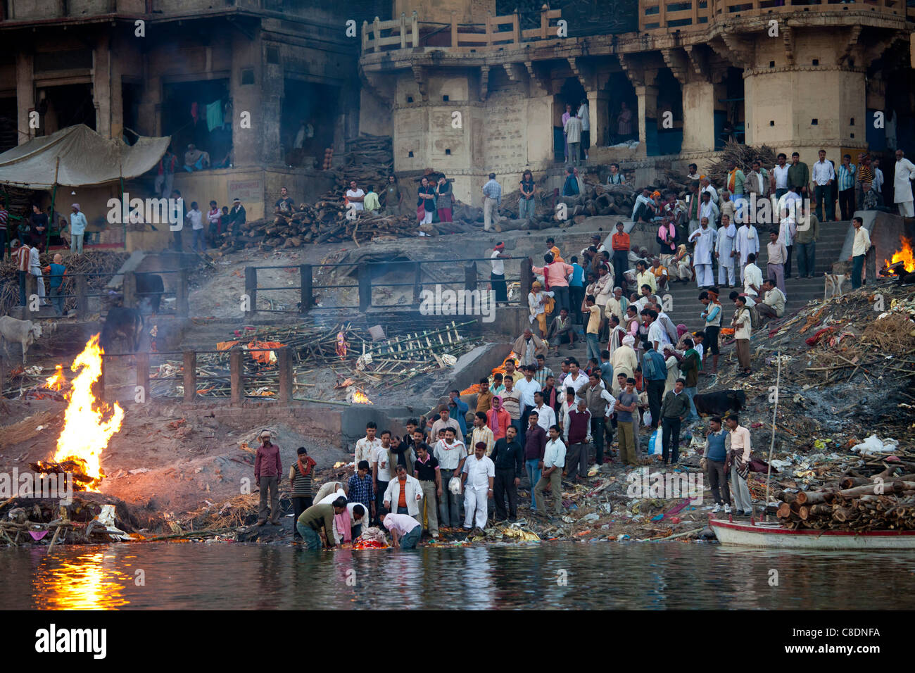 Körper im Fluss Ganges gebadet auf Hindu Einäscherung auf Scheiterhaufen am Manikarnika Ghat in der Heiligen Stadt Varanasi, Benares, Indien Stockfoto