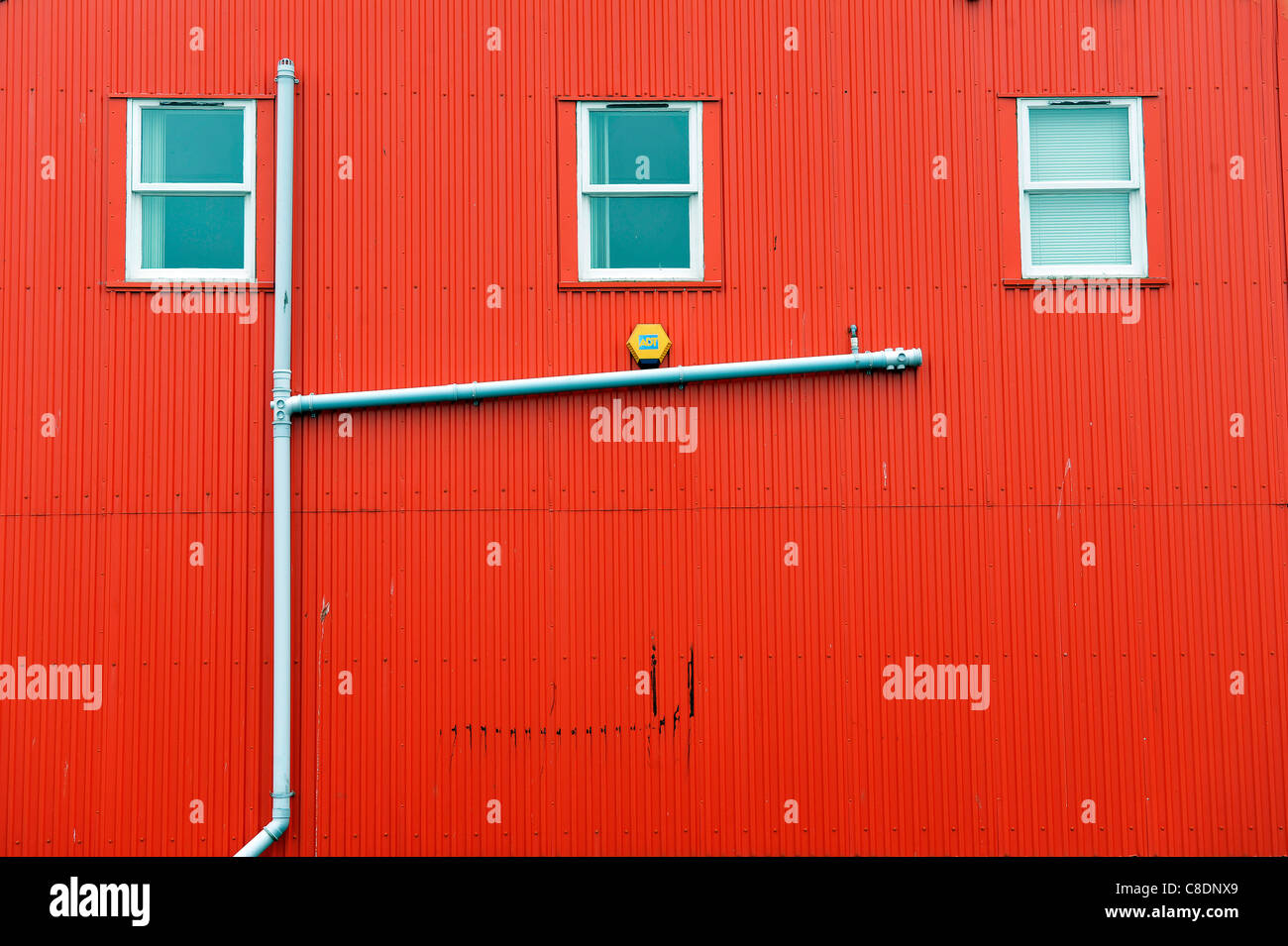 Eine Regenrinne an der Seite ein rotes Wellblech Gebäude in Lerwick, Shetland Islands, Schottland. Stockfoto
