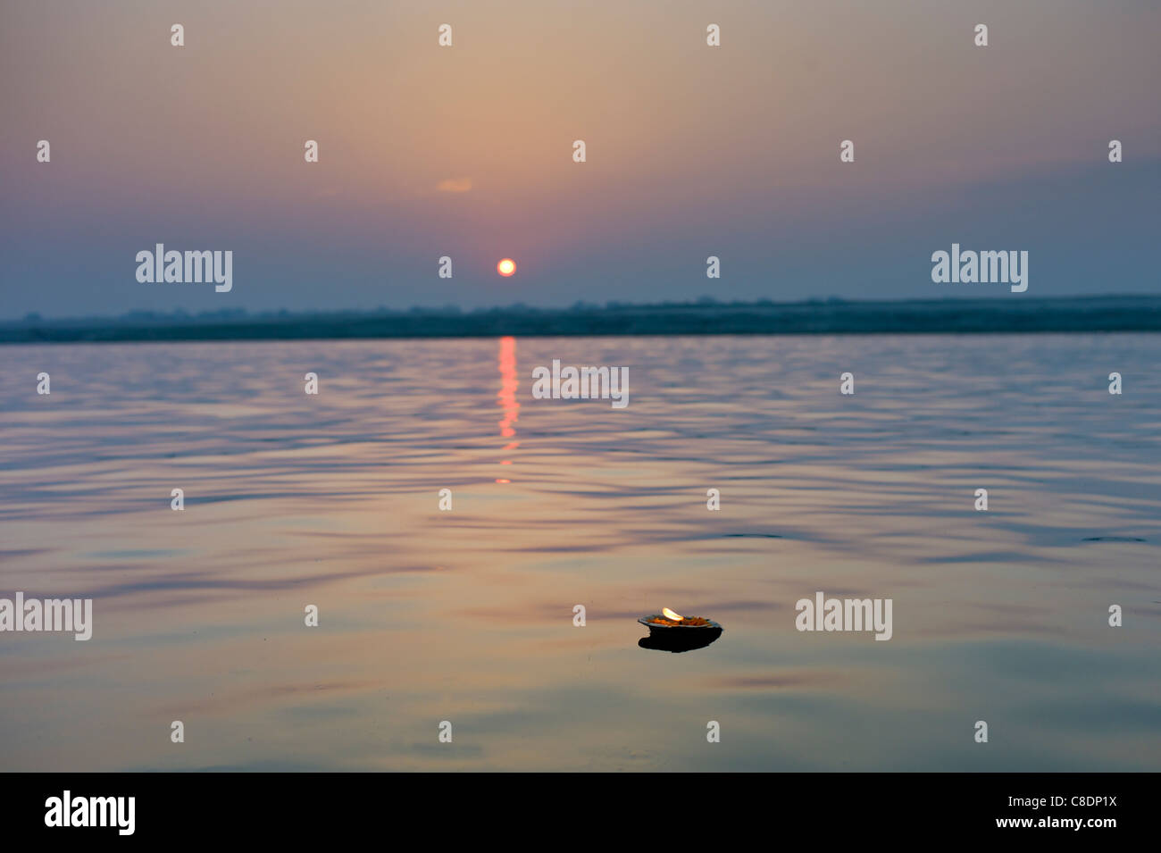 Zeremonielle brennende Kerze trägt hinduistische Gebete am Fluss Ganges bei Sonnenaufgang von der Heiligen Stadt Varanasi, Benares, Nordindien Stockfoto