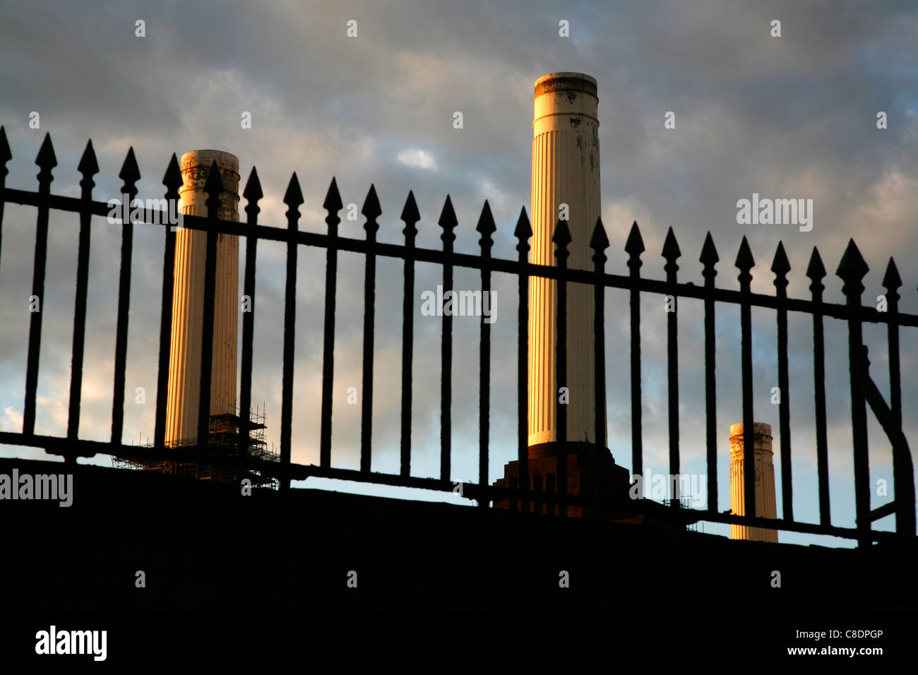 Drei Schornsteine der Battersea Power Station sichtbar durch eine Reihe von Geländern an Nine Elms, London, UK Stockfoto