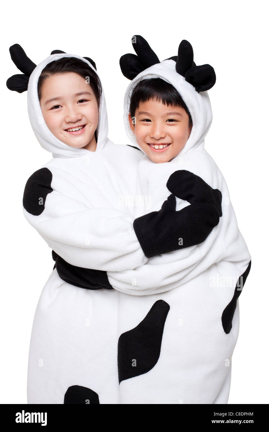 Jungen und Mädchen gekleidet in Kuh Kostüme Umarmung Stockfoto