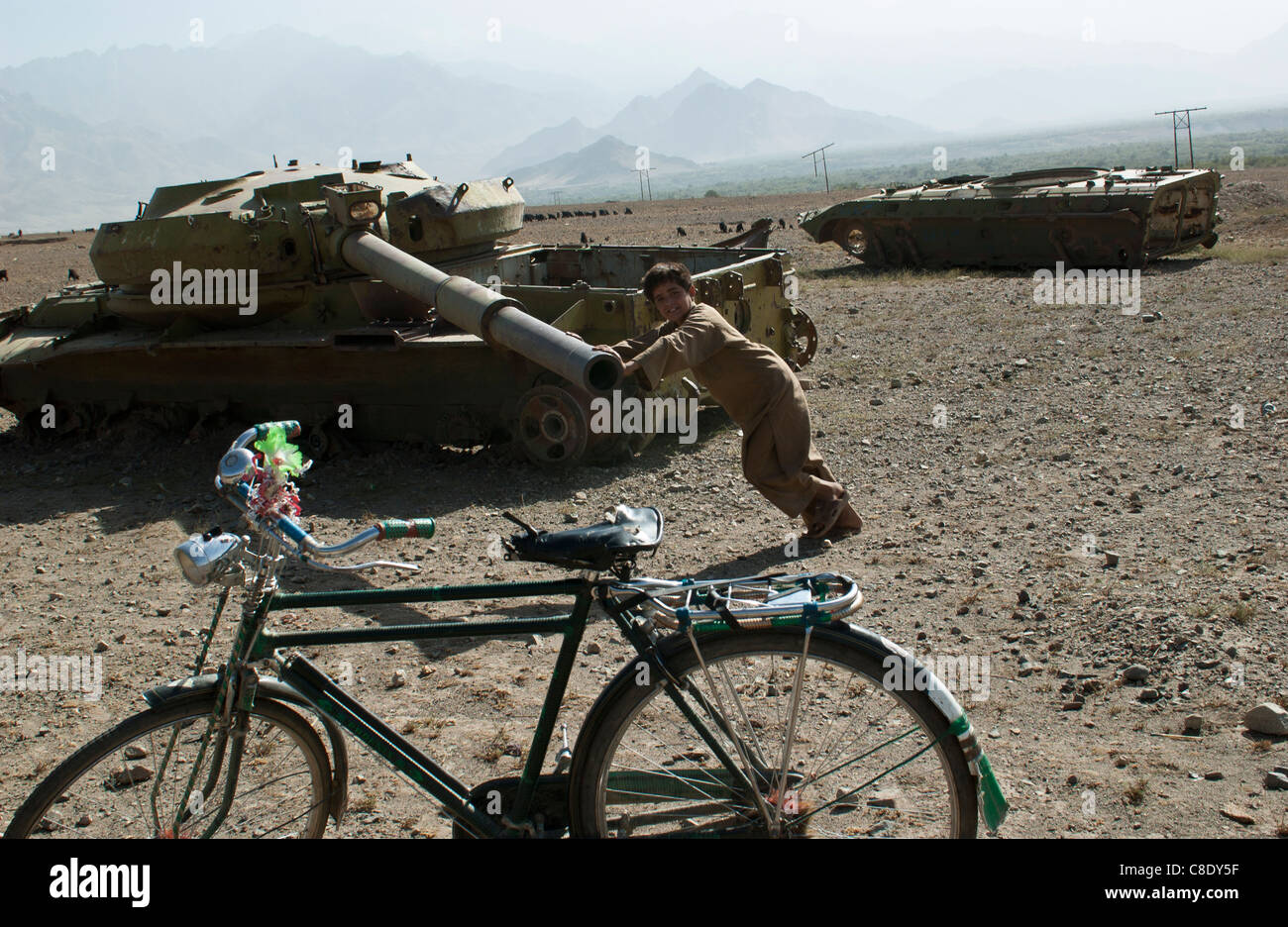 Ein Kind spielt auf einem verlassenen Sowjet-Ära Tank außerhalb Tawakh, in der Nähe der Panjshir-Tal, Afghanistan, Oktober 2004 Stockfoto