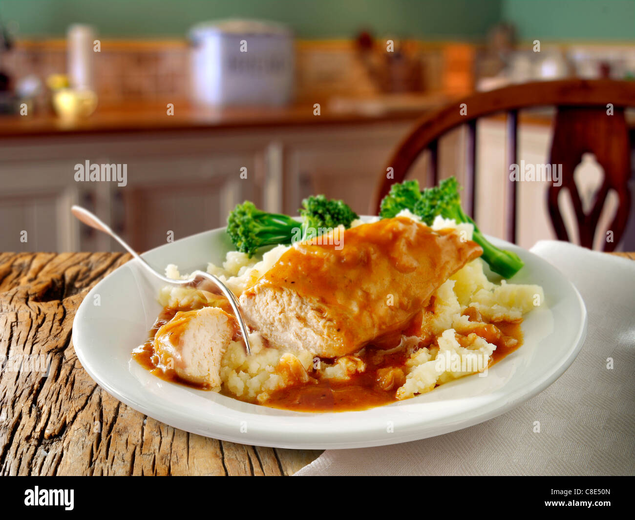 Traditionelles Hähnchenbraten Abendessen auf einem Teller auf einem serviert Holztisch in einer Küche Stockfoto