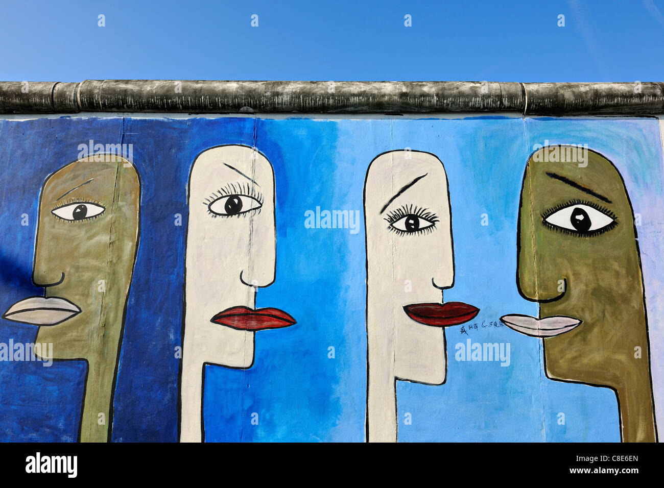 Detail der bemalten Gesichtern Graffiti auf der Berliner Mauer an der East Side Gallery in Berlin, Deutschland, Europa Stockfoto