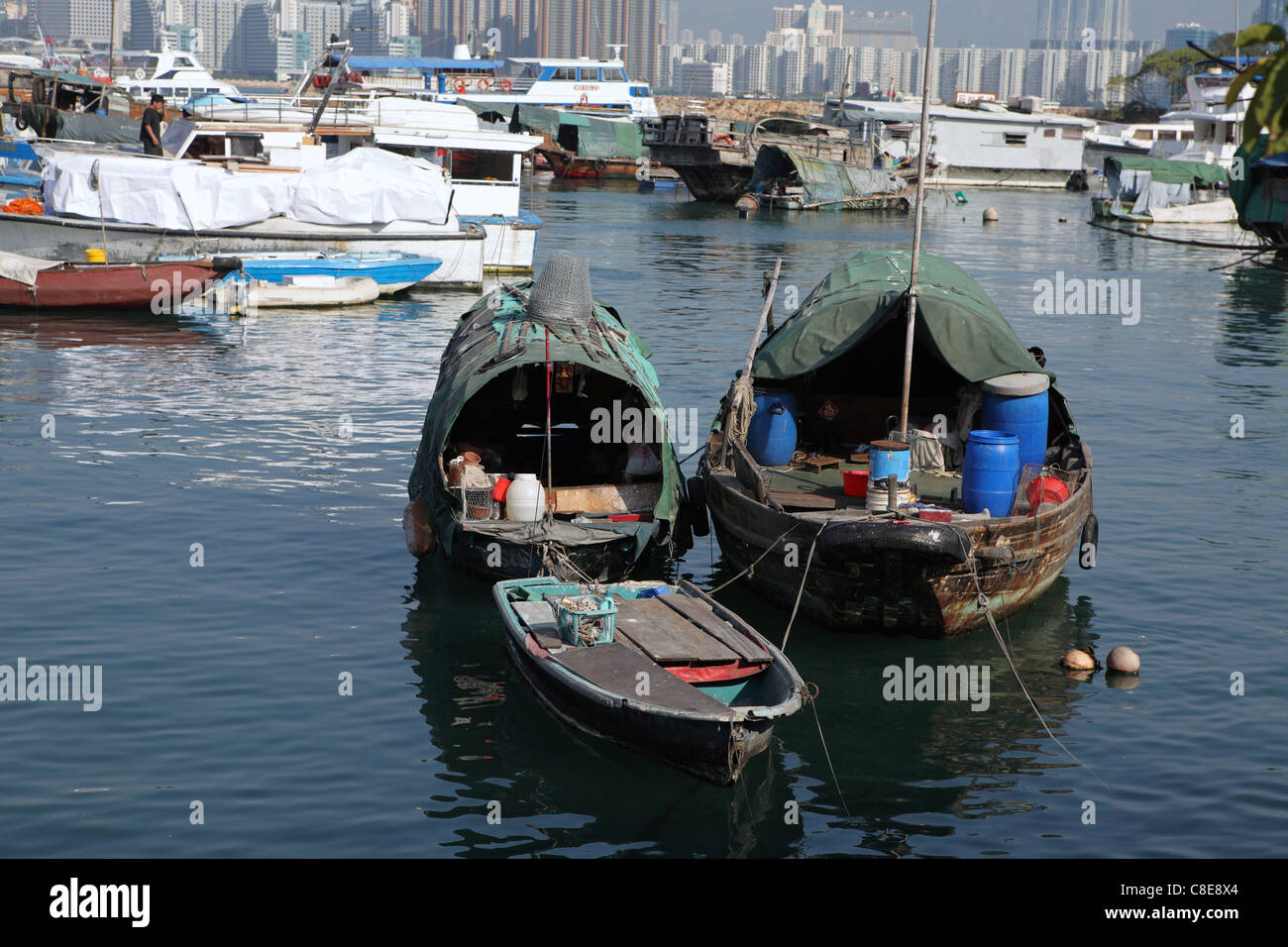 baufälliges Haus Angelboote/Fischerboote in Hong Kong Victoria Harbor, China. Mit wohlhabenden Wolkenkratzer-Skyline hinter am Horizont Stockfoto