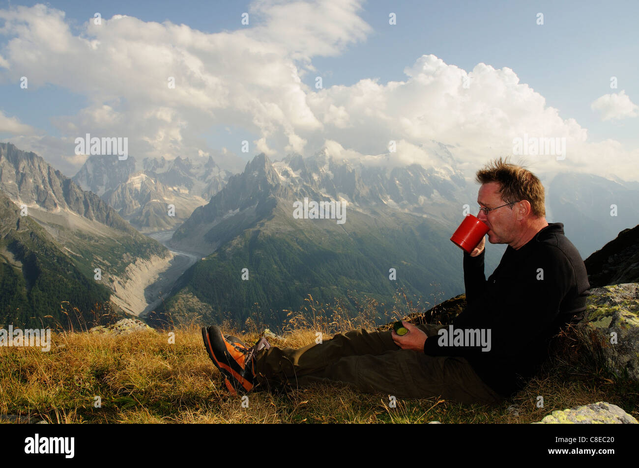Ein Mann Teetrinken bei Sonnenuntergang auf einem wild Camp in den französischen Alpen Stockfoto