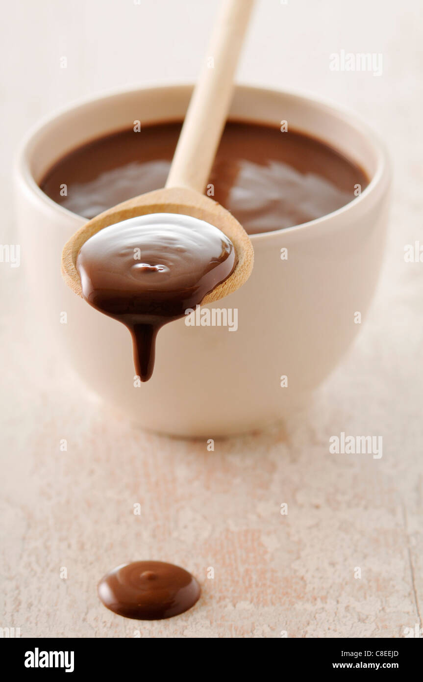Schüssel und Löffel geschmolzene Schokolade Stockfoto