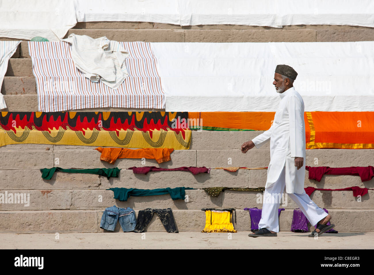 Indischer Mann geht vorbei an Wäsche trocknen auf den Stufen des Kali Ghat am The Ganges-Fluss in Stadt Varanasi, Benares, Indien Stockfoto