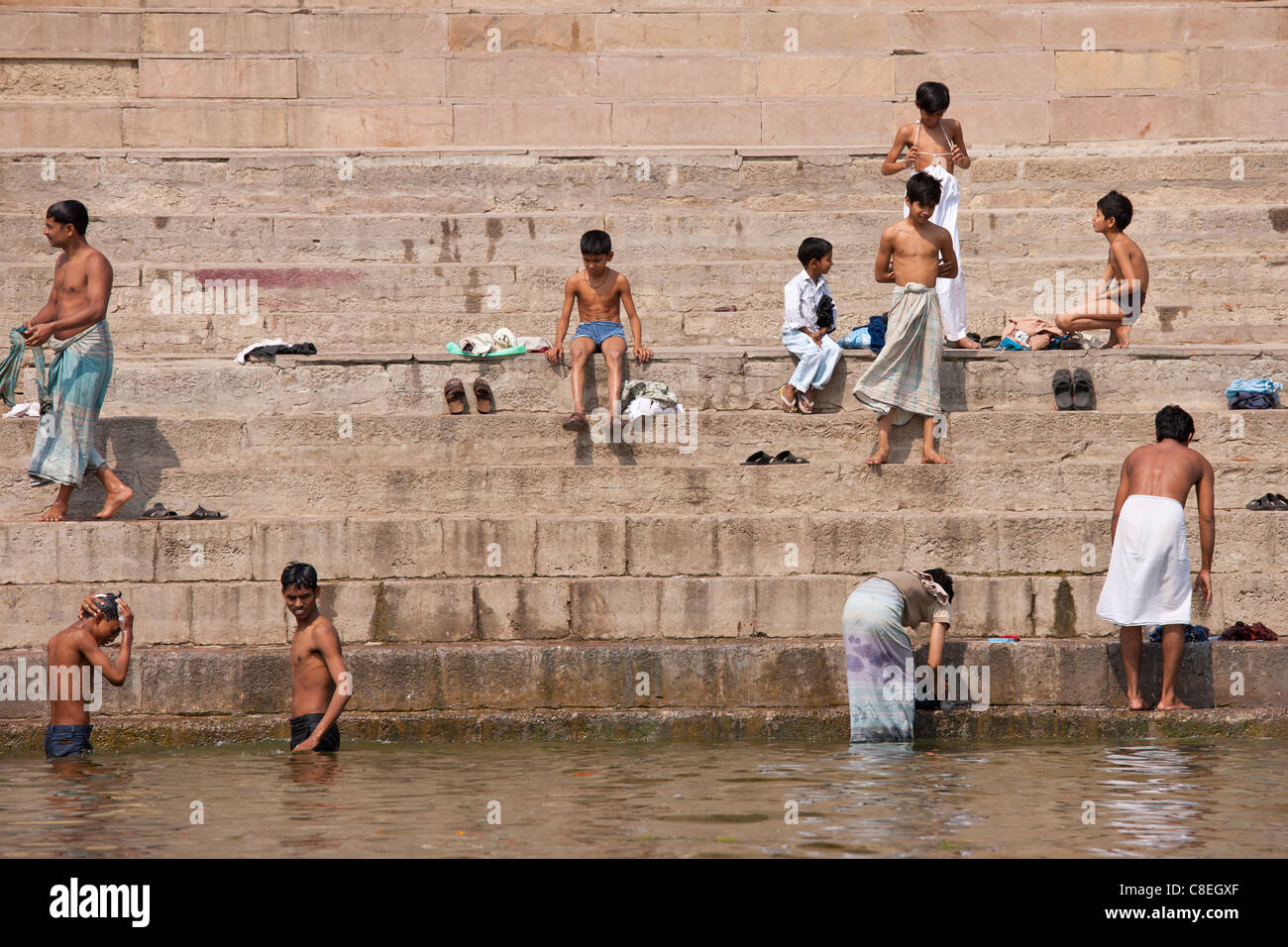 Indisch-hinduistischen Pilger Männer und jungen Baden in der Ganges-Fluss durch die Schritte der Ghats in der Heiligen Stadt Varanasi, Benares, Indien Stockfoto