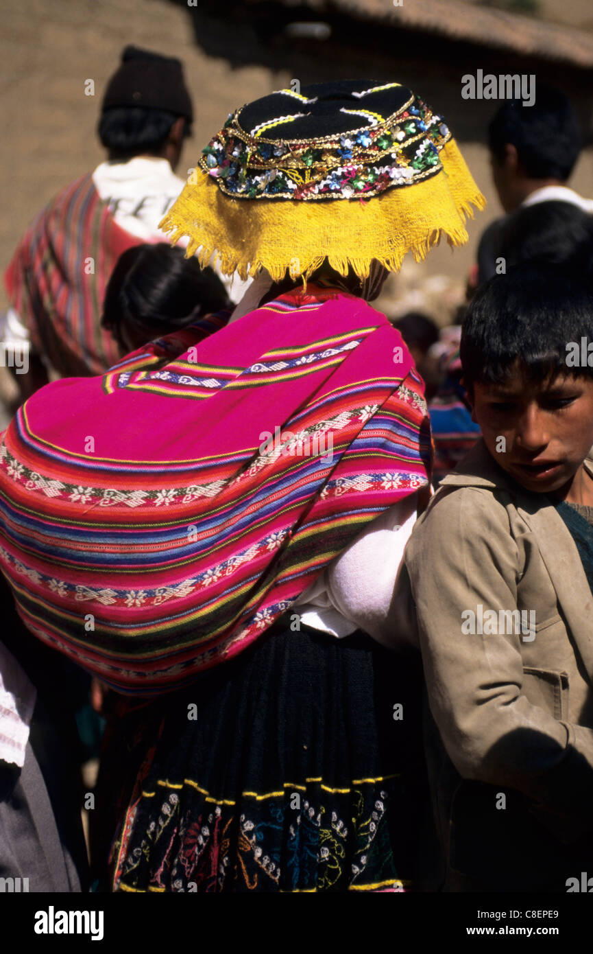 Paucartambo, Peru. Frau trägt Tracht und ein Baby in einem Manta auf dem Rücken tragen. Stockfoto