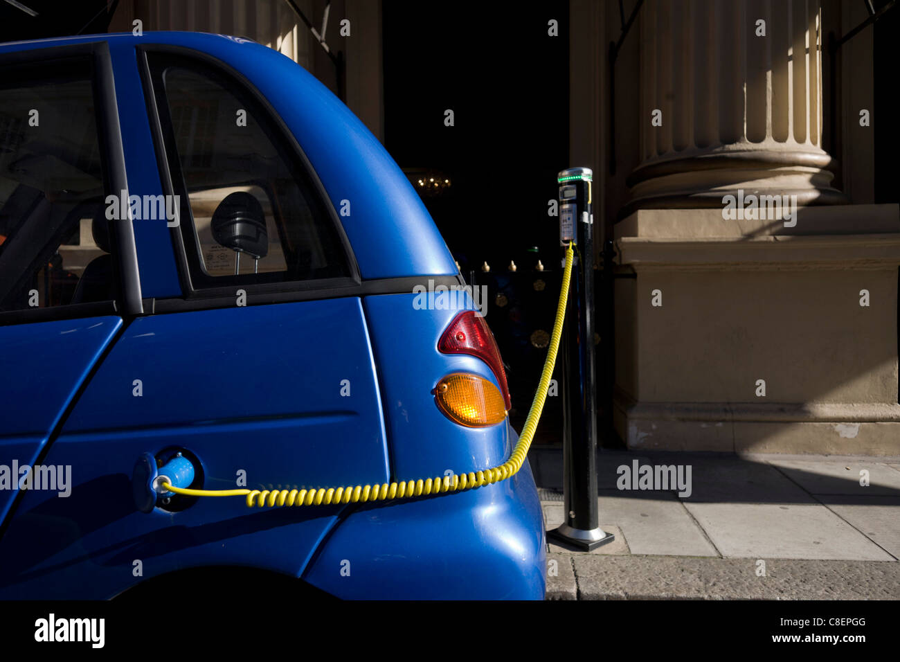Eine Stromkabel Stecker an die Stelle einer Benzin-Kappe während des Aufladens G-Wiz-Auto im Zentrum von London. Stockfoto